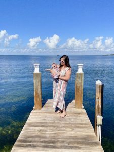 Rachel and her daughter on a dock, with a bay view behind them