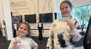 Two girls holding up their Cybrarium cards