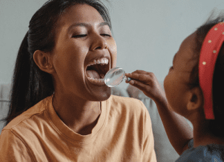 5 Things Your Child’s Dentist Wishes You Knew | Dr. Bob Pediatric Dentist A young girl plays dentist with her mom, holding a magnifying glass up to check her teeth