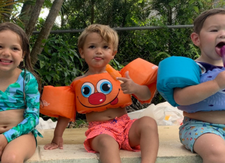 Three kids eating popsicles by the pool