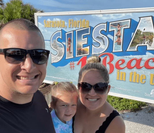 Holly's son with his family in front of a Siesta Beach sign