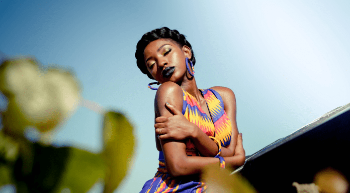 A woman in a brightly colored dress, giving herself a hug