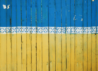 Ukraine in Crisis: How Miami Moms Can Engage & Make a Difference A fence painted like the Ukrainian flag in Kyiv, Ukraine