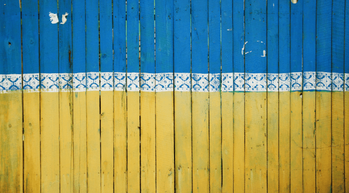Ukraine in Crisis: How Miami Moms Can Engage & Make a Difference A fence painted like the Ukrainian flag in Kyiv, Ukraine