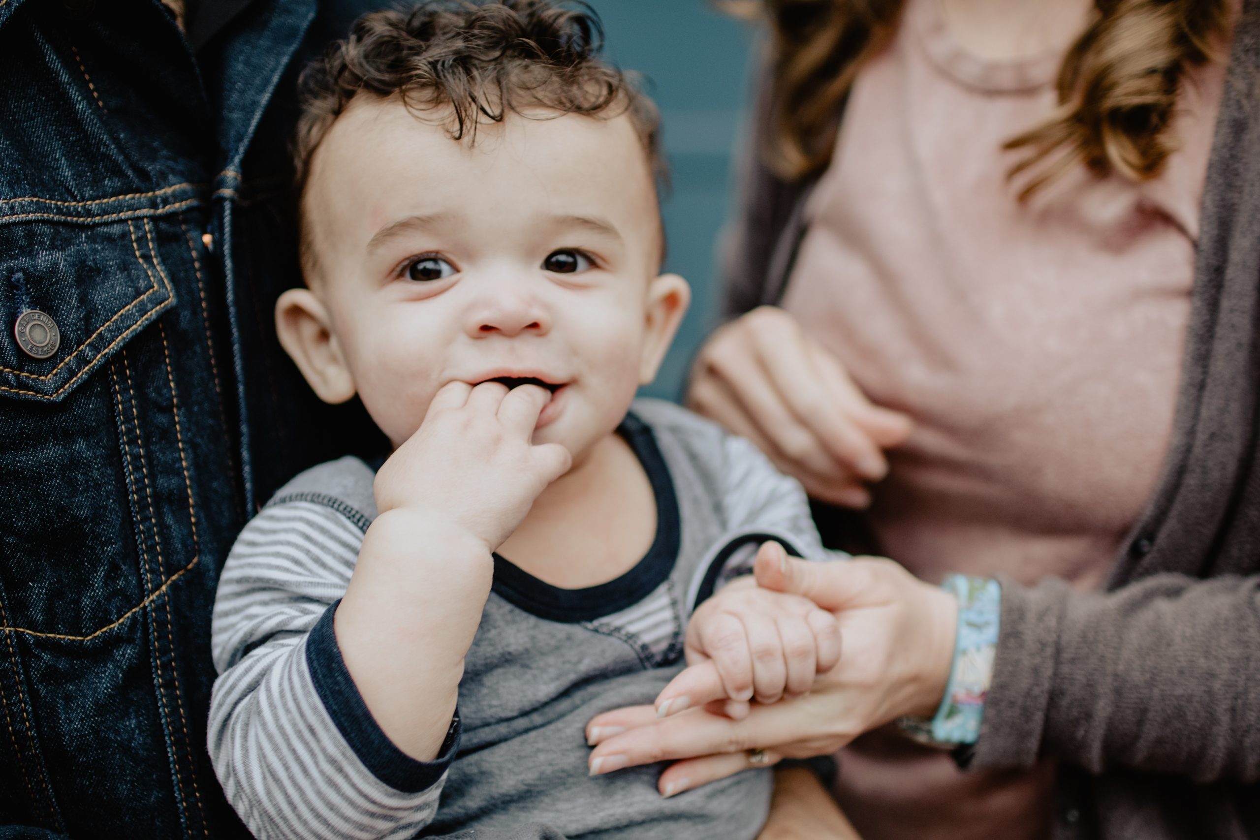 Families and transitions: A little boy, pictured with his parents, holding his mother's hands