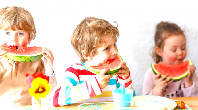 Three children enjoying slices of watermelon as a healthy snack