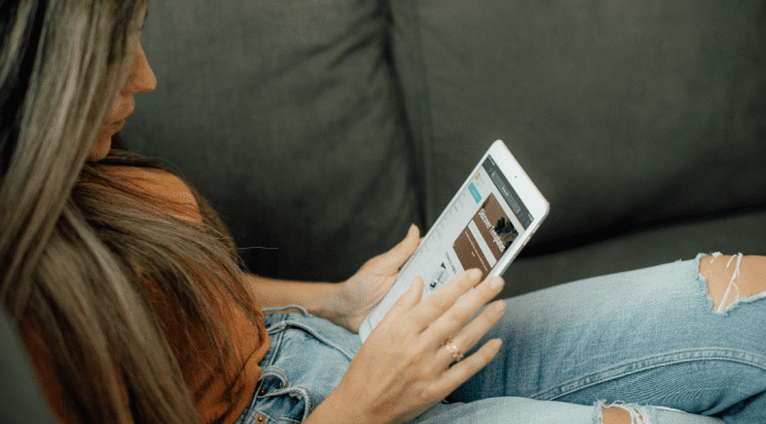 Image: Woman sitting and reading on her tablet (Top 10 Blog Posts of 2021 Lynda Lantz Editor Miami Mom Collective)