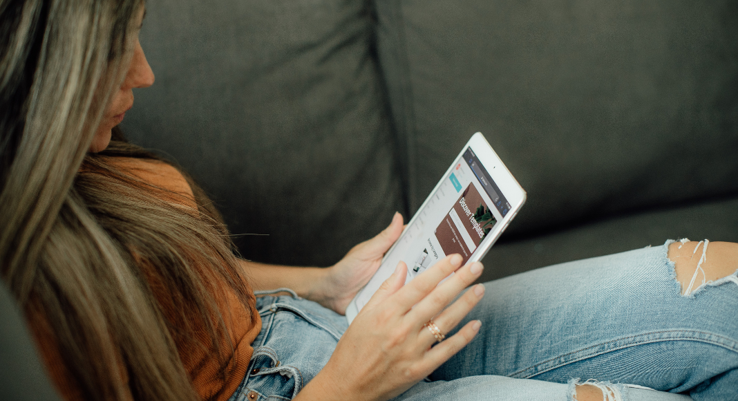 Image: Woman sitting and reading on her tablet (Top 10 Blog Posts of 2021 Lynda Lantz Editor Miami Mom Collective)