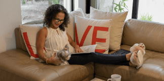 Image: Adita relaxing on her couch with a book (Mama, It's Time to Prioritize YOU! Adita Lang Contributor Miami Mom Collective)