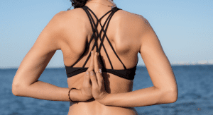 Image: A woman with her hands behind her back in prayer pose
