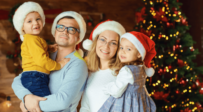 Healthy Holidays: A Survival Guide | Part 2 Image; A family wearing Santa hats and standing in front of a Christmas tree (Healthy Holidays: A Survival Guide | Part 2 Dina Garcia Contributor Miami Mom Collective)