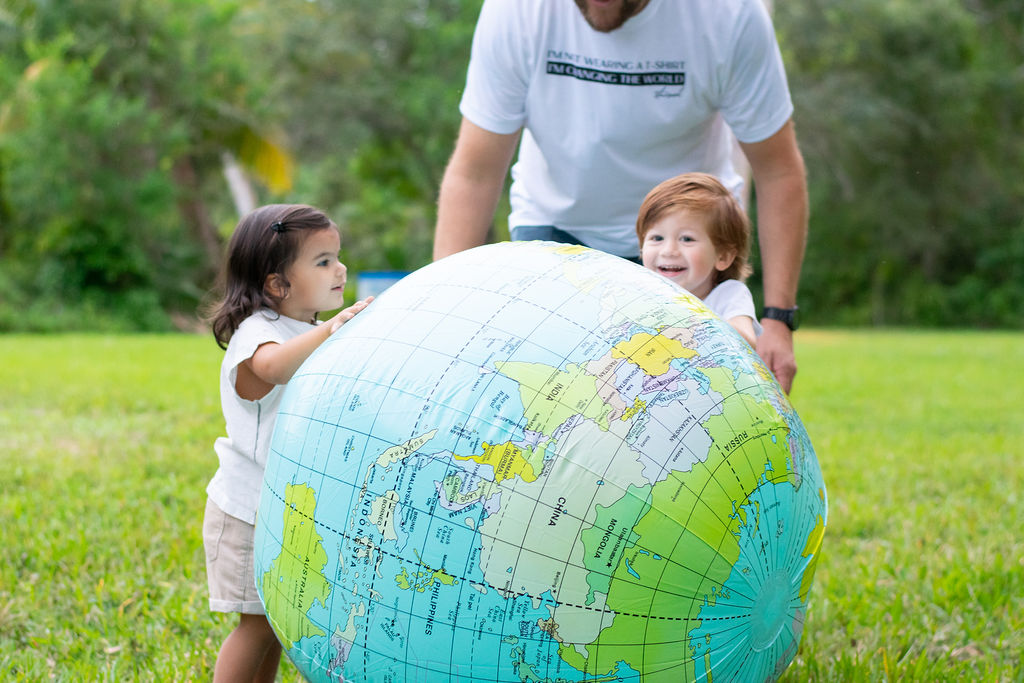 Image: Two children playing together, holding an inflatable globe