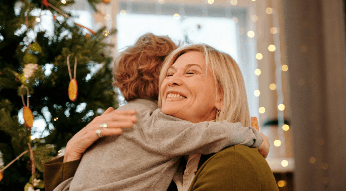 Image: A grandmother hugging her grandson at Christmas (Holiday Travel and Gatherings: Protecting Your Family From COVID & Flu Lynda Lantz Editor Miami Mom Collective)