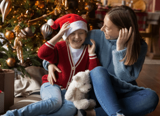 Image: A mother and daughter sitting in front of their Christmas tree