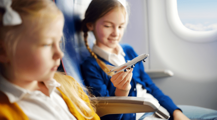 Holiday Travel: The Ultimate Prep List for Smooth Family Travel Image: Two girls sitting together on an airplane (Holiday Travel: The Ultimate Prep List for Smooth Family Travel Vanessa Santamaria Contributor Miami Mom Collective)
