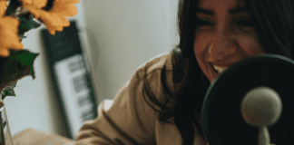 Listening for My Sanity: My Top 10 Podcasts Image: A woman hosting a podcast (Listening for My Sanity: My Top 10 Podcasts Alisa Britton Contributor Miami Mom Collective)