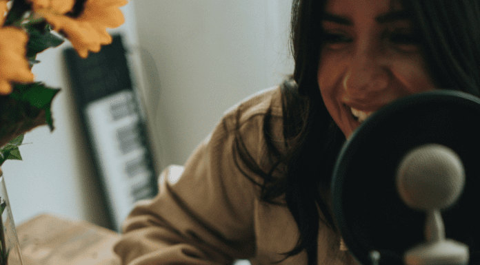 Listening for My Sanity: My Top 10 Podcasts Image: A woman hosting a podcast (Listening for My Sanity: My Top 10 Podcasts Alisa Britton Contributor Miami Mom Collective)