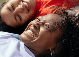 Image: Two multiethnic girls laughing and smiling together (Dental Hygiene Month: Brush Up on Oral Care | Dr. Bob Pediatric Dentist Lynda Lantz Contributor Miami Mom Collective)