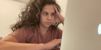 Image: Zoe sitting in front of her computer (5 Tips to Manage Stress through Motherhood Zoe Costa Contributor Miami Mom Collective)