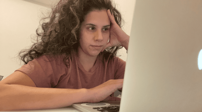 Image: Zoe sitting in front of her computer (5 Tips to Manage Stress through Motherhood Zoe Costa Contributor Miami Mom Collective)