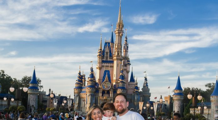 Disney at 50: Walt Disney World’s Golden Birthday Celebration Image: Sandra with her husband and son in front of Cinderella's Castle at Disney (Disney at 50: Walt Disney World's Golden Birthday Celebration Sandra Jacquemin Contributor Miami Mom Collective)