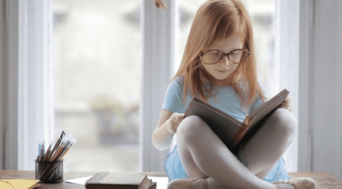 October is Dyslexia Awareness Month Image: A little girl reading a book (October is Dyslexia Awareness Month Sharonda Stewart Contributor Miami Mom Collective)