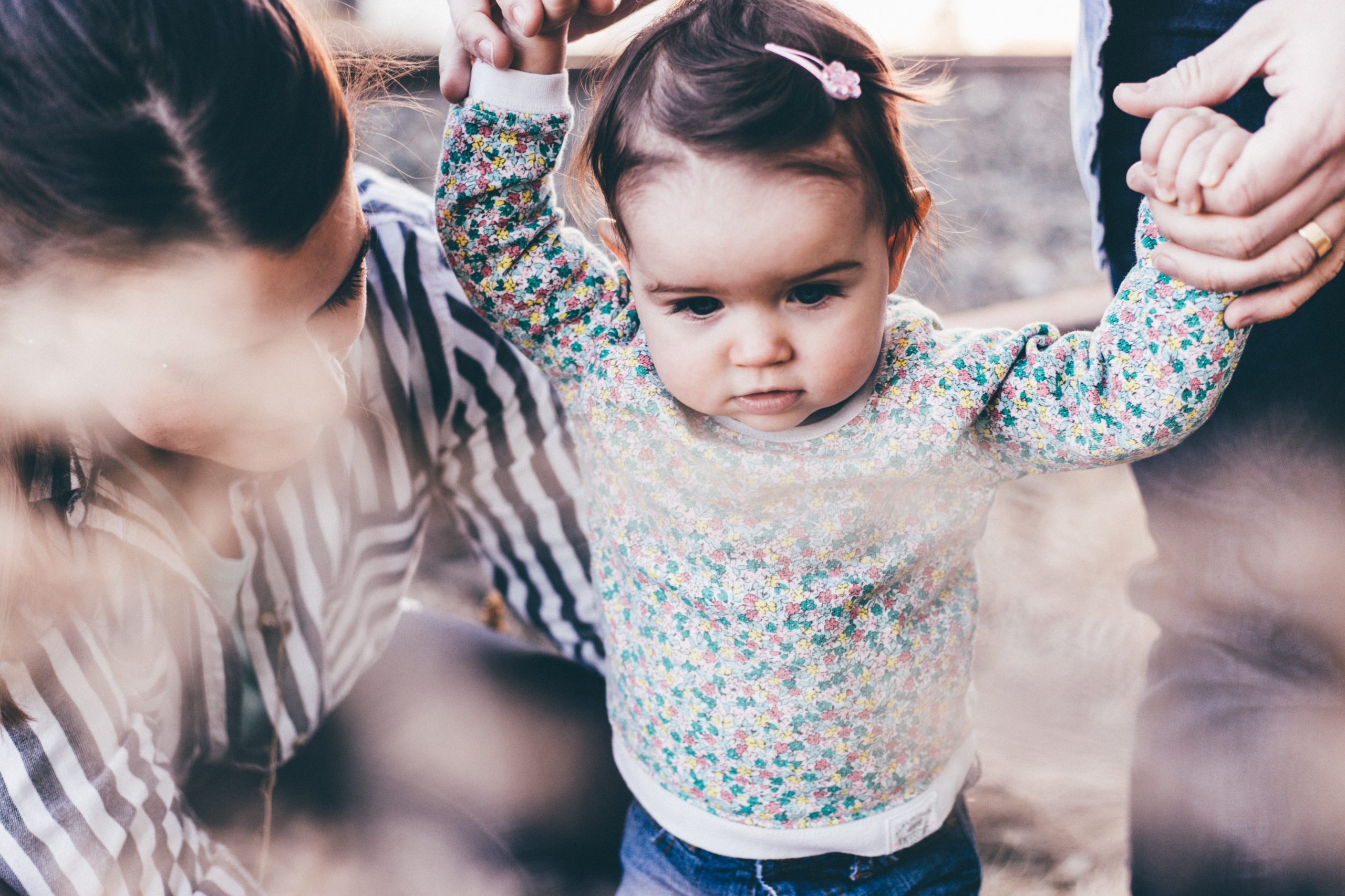 Parents helping their toddler take steps (Designation of Health Care Surrogate for A Minor: What You Should Know Kristina Hernandez Tilson Contributor Miami Mom Collective)