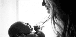 A mother holding her infant (To Parent in a Broken World Kristin Parke Contributor Miami Mom Collective)