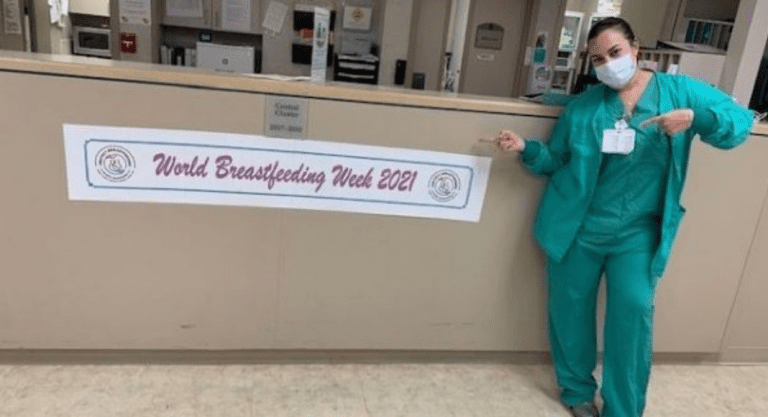 A nurse posing next to a banner for World Breastfeeding Week (World Breastfeeding Week: Raising Global Awareness Alexa Gonzalez Contributor Miami Mom Collective)