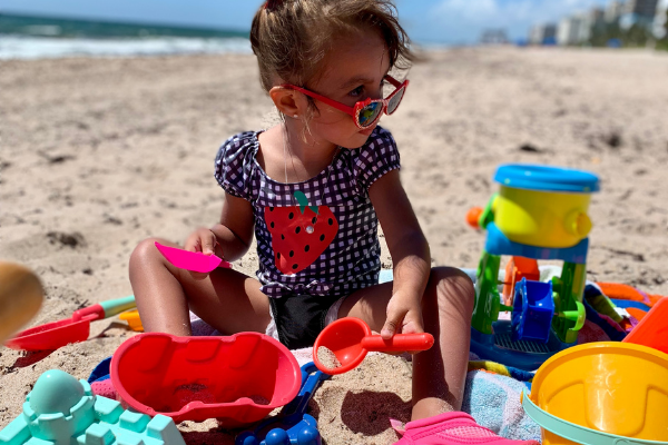 Jessica's daughter playing with sand toys at the beach (Beach More, Stress Less : Beach Day Tips and Hacks Jessica Alvarez-Ducos Contributor Miami Mom Collective)