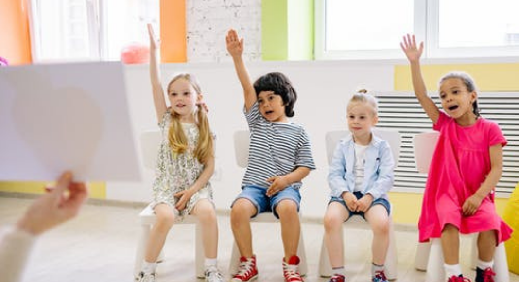 A group of children raising their hands (Your Child Votes YES! Getting Involved at Your Child's School Matters! Holly Farver Contributor Miami Mom Collective)