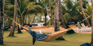 A woman in a hammock reading a book (Summer Reading List for Moms Krystal Giraldo Contributor Miami Mom Collective)