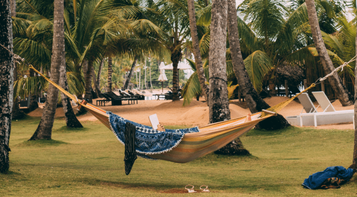 A woman in a hammock reading a book (Summer Reading List for Moms Krystal Giraldo Contributor Miami Mom Collective)
