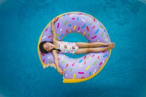 A little girl on a donut shaped inner tube