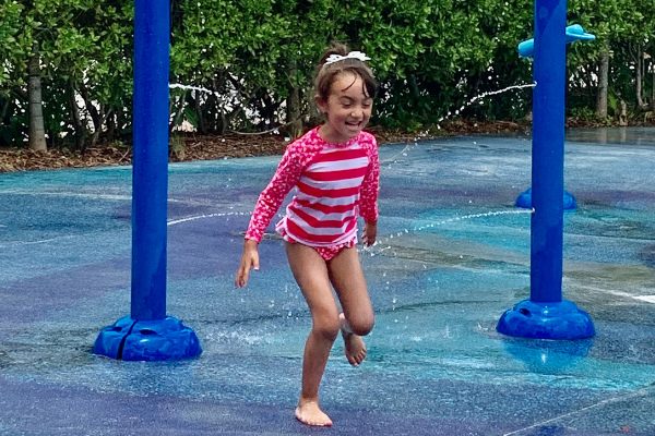 Image: A child enjoys a splash pad at Zoo Miami