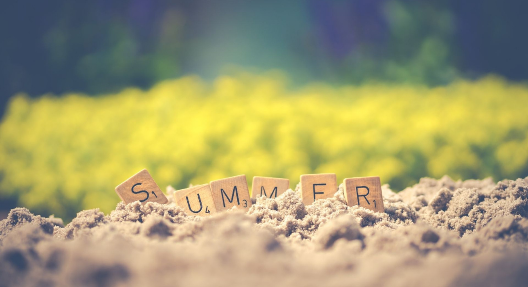 Image: Letter tiles spelling SUMMER in the sand