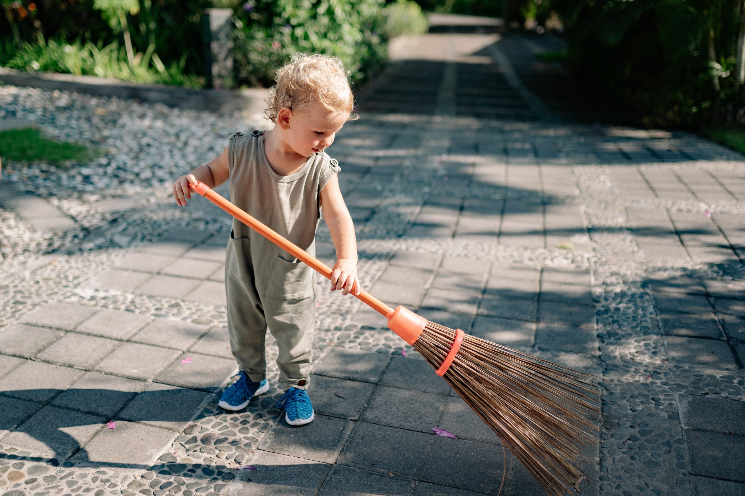A toddler sweeping (Summer Fun that Leads to Lasting NEW Habits for the Entire Family Adita Lang Contributor Miami Mom Collective)