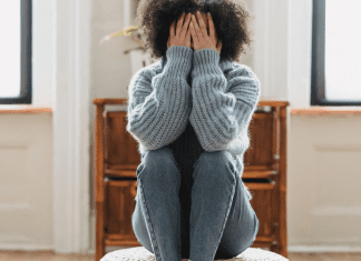 Image: A woman sitting down with her head in her hands (Speak Up: You Matter, Your Opinions Matter Rachelle Haime Contributor Miami Mom Collective)