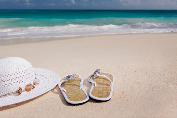 Flip flops and a sun hat on the sand (Lorena Lougedo Contributor Miami Mom Collective)