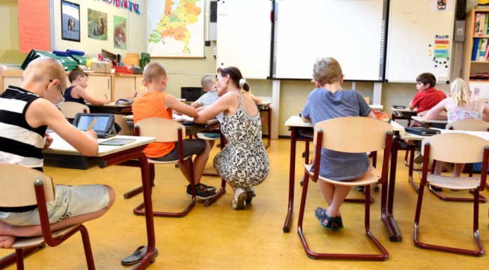 A teacher helping a student in a classroom (Teacher Appreciation Week: Let's Show Appreciation Lorena Lougedo Contributor Miami Mom Collective)