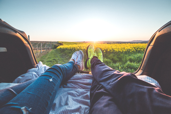 Image: A man and woman watching a sunrise from their car (Car Dates: Let's Get Driving! Lorena Lougedo Contributor Miami Mom Collective)
