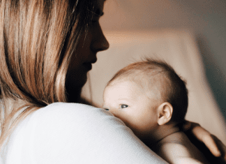 A mom holding her newborn (Choosing Joy and Enjoying the Chaos Kristin Parke Contributor Miami Mom Collective)