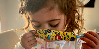 A toddler putting a mask on (Wear a Mask: How To Get Your Toddler to Wear One (and Keep It On!) Alexa Gonzalez Contributor Miami Mom Collective)