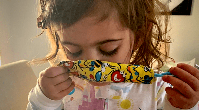 A toddler putting a mask on (Wear a Mask: How To Get Your Toddler to Wear One (and Keep It On!) Alexa Gonzalez Contributor Miami Mom Collective)