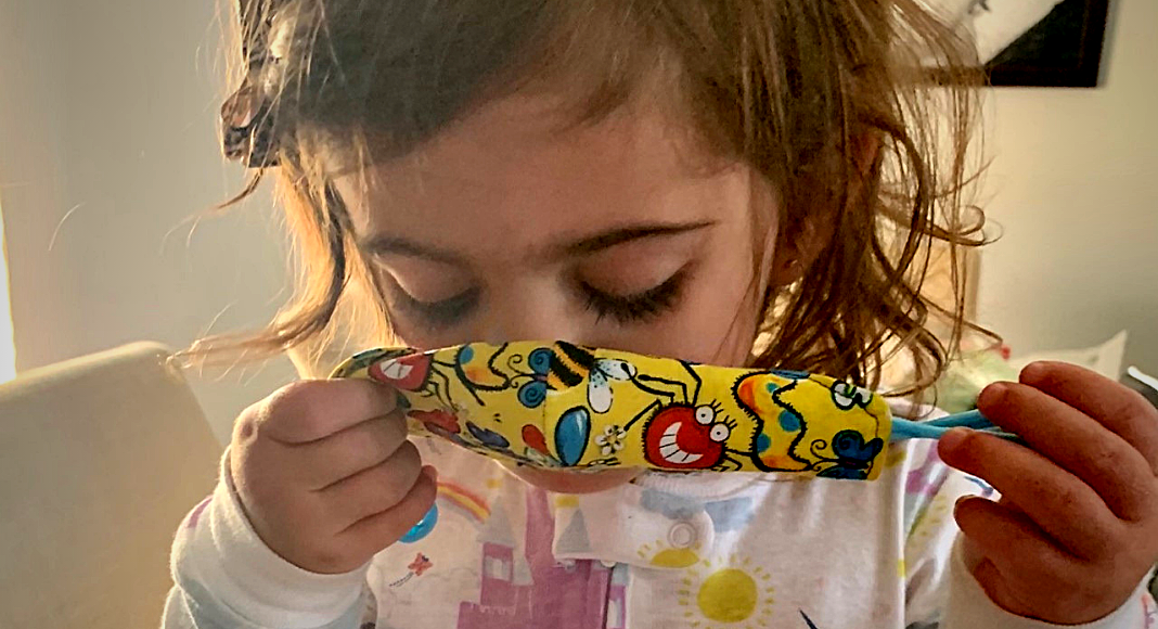 A toddler putting a mask on (Wear a Mask: How To Get Your Toddler to Wear One (and Keep It On!) Alexa Gonzalez Contributor Miami Mom Collective)