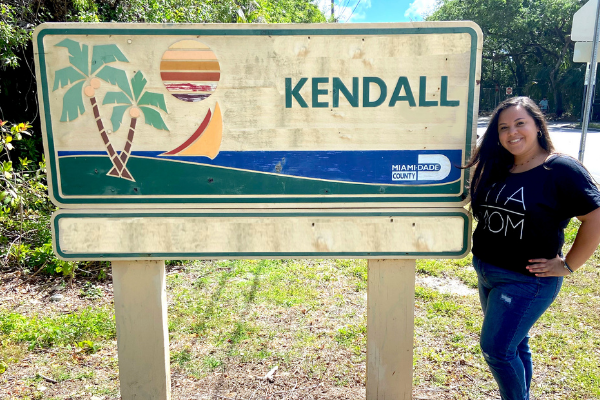 Krystal posing by a Kendall sign (Love Where You Live: Why I Love Kendall Krystal Giraldo Contributor Miami Mom Collective)