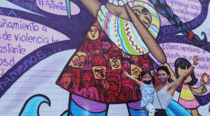 #ChooseToChallenge por el Día Internacional de la Mujer Ana with her daughter in front of a colorful street mural (International Women's Day: This Year, #ChooseToChallenge Ana Caballeros Contributor Miami Mom Collective)