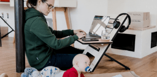 A mom working from home while watching her baby (Daycare & Preschool During the Ongoing Pandemic Bella Behar Contributor Miami Mom Collective)