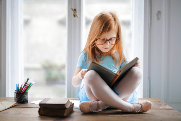 A little girl with a book (Lorena Lougedo Contributor Miami Mom Collective)