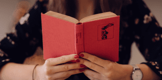 A woman holding an open book (Let's Celebrate: National Reading Across America Day Lorena Lougedo Contributor Miami Mom Collective)